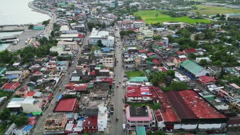 Centro-De-Virac,-Catanduanes-Mostrando-Densos-Edificios-Y-Calles-Junto-A-La-Costa,-Vista-Aérea