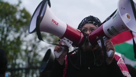 A-Close-Up-Shot-of-an-Arab-Woman-in-a-Keffiyeh-with-Two-Megaphones-Shouting-in-a-Crowd-of-Pro-Palestine-Protestors