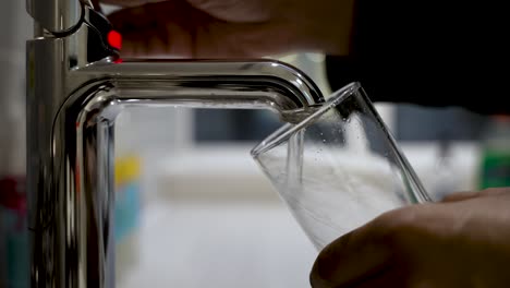 Eine-Person-Nimmt-Einen-Erfrischenden-Schluck-Wasser-Direkt-Aus-Dem-Wasserhahn-In-Ein-Glas