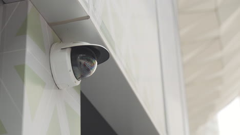 Low-angle-static-shot-of-white-surveillance-camera-with-hood