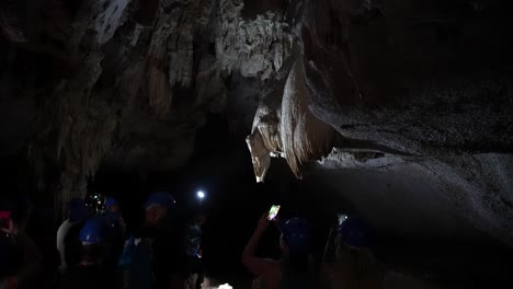 Touristen-Erkunden-Mit-Taschenlampen-Die-Geheimnisvolle-Eishöhle,-Thailand