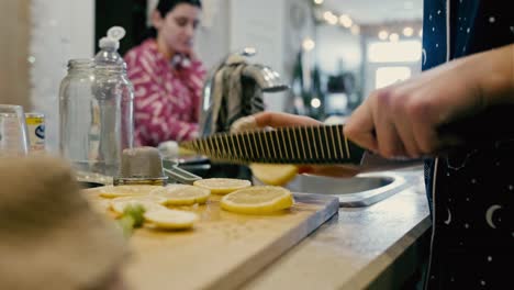 A-handheld-shot-captures-a-person's-hands,-adorned-with-a-plaster-on-her-finger,-cutting-a-lemon-with-a-dull-knife