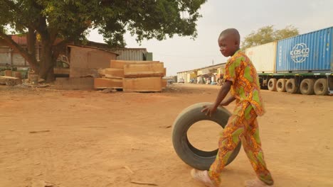 Un-Niño-Negro-Juega-Con-Un-Neumático-De-Coche-En-Las-Calles-De-Madagascar