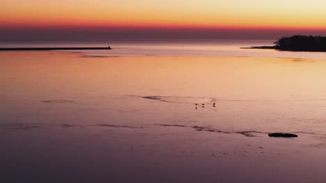 Ruhiger-Sonnenuntergang-In-Port-Colborne-Mit-Spiegelungen-Auf-Ruhigem-Wasser,-Silhouette-Des-Piers-Sichtbar