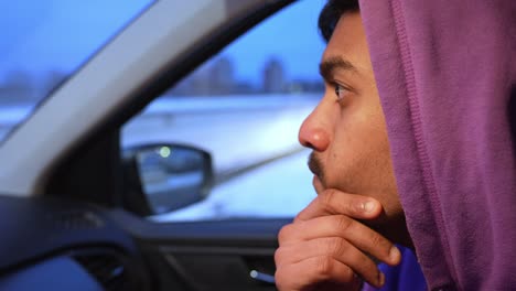 Man-sitting-in-car-and-thinking,-close-up-face-view