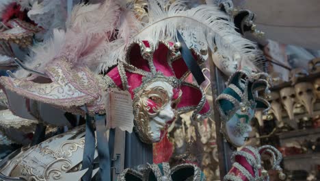 Opulent-Venetian-Mask-with-Feathers-hanging-on-a-storefront