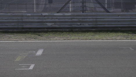 Autos-De-Carrera-Pasando-La-Línea-De-Meta-A-Alta-Velocidad-En-El-Circuito-De-Carreras-En-Cámara-Lenta