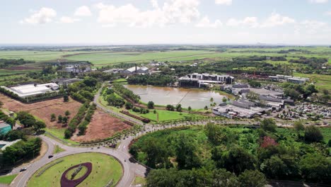 Mahogany-shopping-mall-in-mauritius-with-lush-greenery-and-pond,-aerial-view