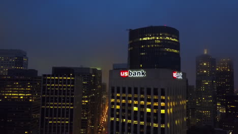 Drone-tilting-toward-the-night-lit-US-bank-tower,-in-gloomy-San-Francisco,-USA