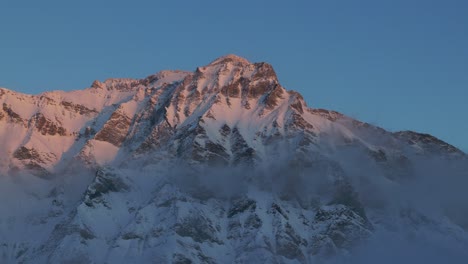 Erleben-Sie-Die-Schönheit-Des-Sonnenaufgangs-über-Der-Silhouette-Einer-Schneebedeckten-Bergkette-Durch-Diese-Faszinierende-Drohnenaufnahme