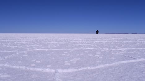 Paseos-En-Motocicleta-Del-Salar-De-Uyuni-De-ángulo-Bajo-Hacia-El-Horizonte,-Cielo-Azul