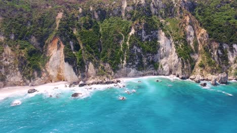 Petani-beach-with-turquoise-waters-and-rugged-cliffs-in-kefalonia,-greece,-aerial-view