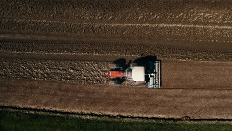 Toma-Aérea-De-Un-Tractor-Solitario-Arando-Campos-Fértiles-Al-Atardecer