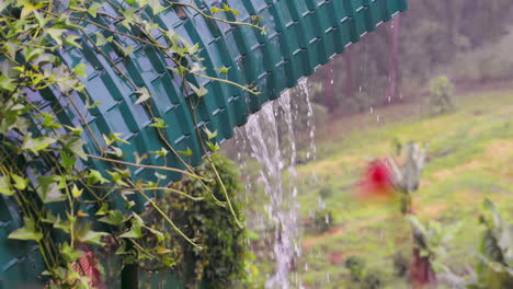 Fuertes-Lluvias-Sobre-El-Techo-De-Metal-Azul-En-Un-Exuberante-Jardín