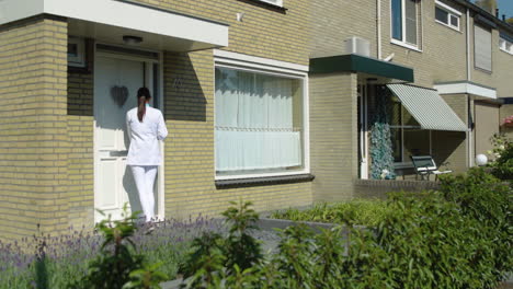 Woman-nurse-going-into-elderly-home-for-health-check-up,-female-home-caregiver