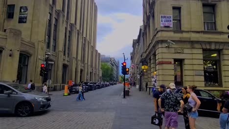 People-leaving-Notre-Dame-church-across-the-street-in-old-Montreal-as-others-approach-the-church-on-a-busy-summer-day-with-many-foreign-tourists-out-shopping-in-trendy-vintage-iconic-surrounding-area