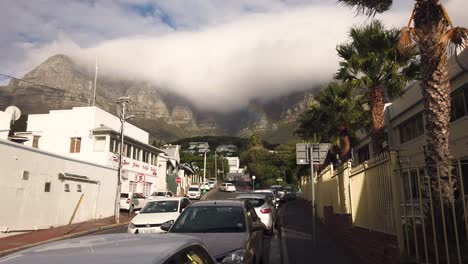 Imágenes-En-Cámara-Lenta-Del-Tráfico-En-Una-Calle-De-La-Bahía-Del-Campamento-Con-Nubes-Sobre-La-Montaña-De-La-Mesa-Visibles-Al-Fondo