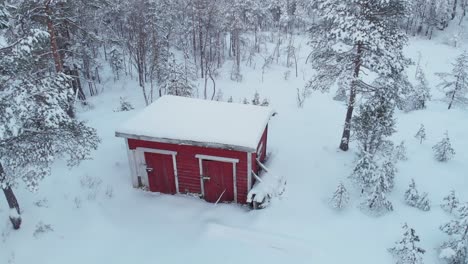 Eine-Purpurrote-Hütte-In-Einem-Schneebedeckten-Winterwald---Luftaufnahme-Einer-Drohne