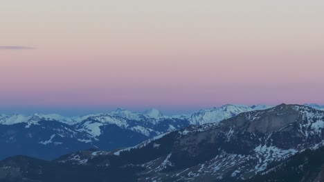 Maravíllate-Ante-La-Pintoresca-Silueta-De-Una-Cadena-Montañosa-Cubierta-De-Nieve-Durante-El-Amanecer,-Capturada-Desde-La-Perspectiva-De-Un-Dron
