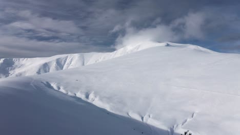 Riesiger-Schneebedeckter-Papusa-Gipfel-Unter-Bewölktem-Himmel,-Iezer-Papusa-Gebirge,-Arges,-Rumänien