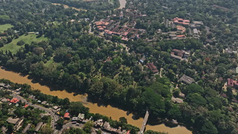 Peradeniya-Sri-Lanka-Aerial-v8-high-birds-eye-view-flyover-University-campus-capturing-A1-road-bridge-crossing-Mahaweli-river,-Kandy-suburb-and-mountain-landscape---Shot-with-Mavic-3-Cine---April-2023