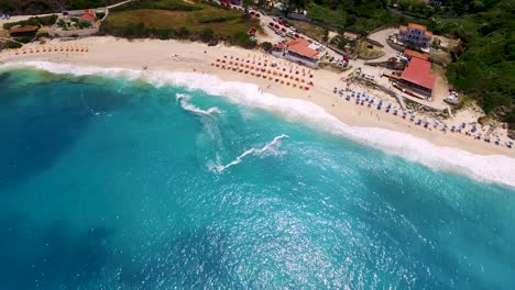 Playa-De-Petani-Con-Aguas-Turquesas-Y-Bañistas-En-Cefalonia,-Grecia,-En-Verano,-Vista-Aérea