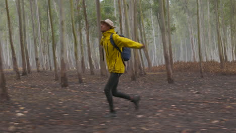 Close-up-Drone-shot-of-a-male-Tourist-running-and-enjoying-the-dense-wild-forest-of-Nepal-in-Terai-region