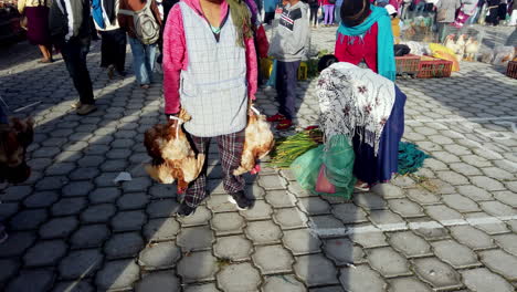 Brillante-Día-De-Mercado-En-Otavalo,-Ecuador,-Con-Lugareños-Vestidos-Con-Trajes-Tradicionales-Y-Productos-Para-La-Venta.