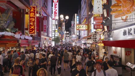 Slow-moving-shot-thought-the-busy-crowds-at-the-night-walking-street-of-Dotonbori,-Chuo-Ward,-Osaka-Japan