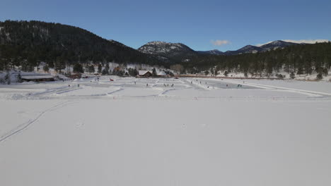 Ice-skating-skate-hockey-rink-lake-pond-hockey-winter-Etown-Evergreen-Lake-house-Denver-golf-course-Colorado-aerial-cinematic-drone-sunny-bluesky-morning-winter-fresh-snow-forward-upward-motion