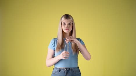 Caucasian-blonde-young-lady-drinks-a-bottle-of-glass-water-in-studio-chroma-body-shot