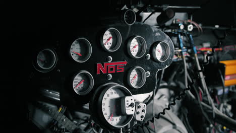 Quick-Pan-revealing-the-NOS-control-dials-for-an-American-drag-race-car-sitting-in-the-garage