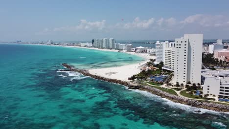 Cancun-coastline-with-turquoise-waters-and-beachfront-hotels,-sunny-day,-aerial-view