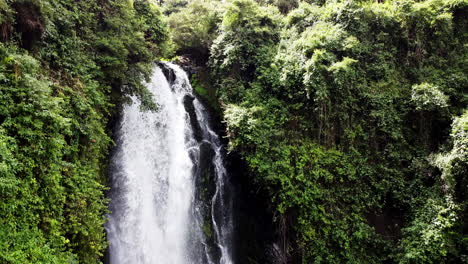 Lush-greenery-encasing-a-cascading-waterfall-in-Banos,-Ecuador,-with-a-viewing-platform
