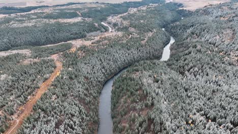 Aerial-View-Of-A-River-Runs-Through-Winter-Forest-Near-Sun-Valley,-Idaho-USA