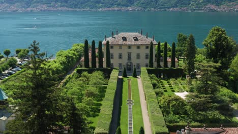 Villa-balbiano,-lush-gardens,-and-lake-como-on-a-sunny-day,-aerial-view