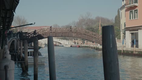 Wooden-bridge-over-serene-Venetian-canal,-Italy