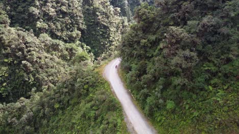 Luftaufnahmen-Von-Mountainbikern,-Die-Die-Todesstraße-In-Den-Bergen-Boliviens-Entlangradeln