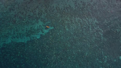 Aerial-drone-video-of-tourists-rowing-in-a-colorful-kayak-in-tropical-Hawaiian-exotic-destination-with-turquoise-calm-ocean-surface