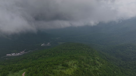 Aerial-view-through-clouds,-high-in-the-gloomy-Joshinetsu-National-Park-in-Japan