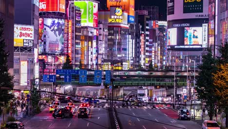 Tilt-Time-Lapse-at-downtown-Shinjuku-Kabukicho-Tokyo-City-at-Night-as-traffic,-trains,-pedestrians-and-city-lights-pass-by