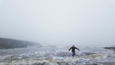 Young-boy-standing-on-the-rocks-on-a-coastal-landscape