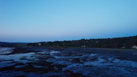 Vista-Por-Drones-Del-Río-San-Lorenzo-Durante-La-Marea-Baja-En-Dirección-A-Un-Pueblo-En-Gaspésie