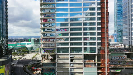 Graffiti-tower-building,-in-downtown-Los-Angeles,-USA---descending,-drone-shot