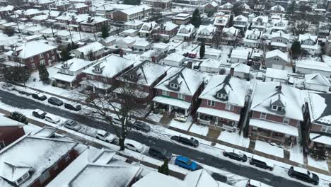Cinematic-drone-flight-over-snow-covered-american-village-after-snowstorm-at-night