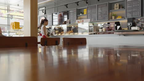 Una-Joven-Haciendo-Un-Pedido-En-Una-Cafetería-Internacional.