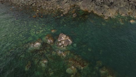 Vista-De-Arriba-Hacia-Abajo-De-Rocas-En-Aguas-Verdes-Poco-Profundas-En-La-Isla-Moresby,-Canadá-Desde-Un-Dron-Aéreo