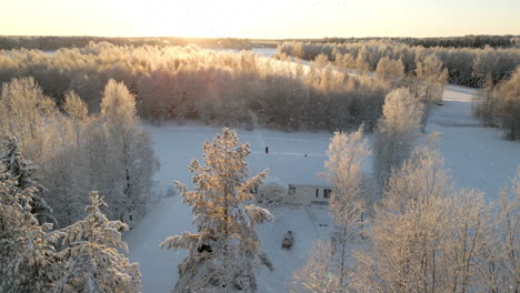 Resplandor-Del-Atardecer-En-El-Bosque-Nevado-Con-Casa-Rústica,-Sereno-Paisaje-Invernal,-Luz-De-Hora-Dorada