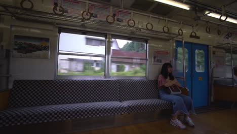 A-Japanese-woman-with-bangs-sits-comfortably-on-a-plush-cushion-aboard-a-smoothly-moving-train,-journeying-towards-Fujikawaguchiko