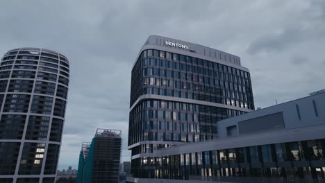 Aerial-drone-view-of-modern-office-business-building-with-big-windows-at-dusk